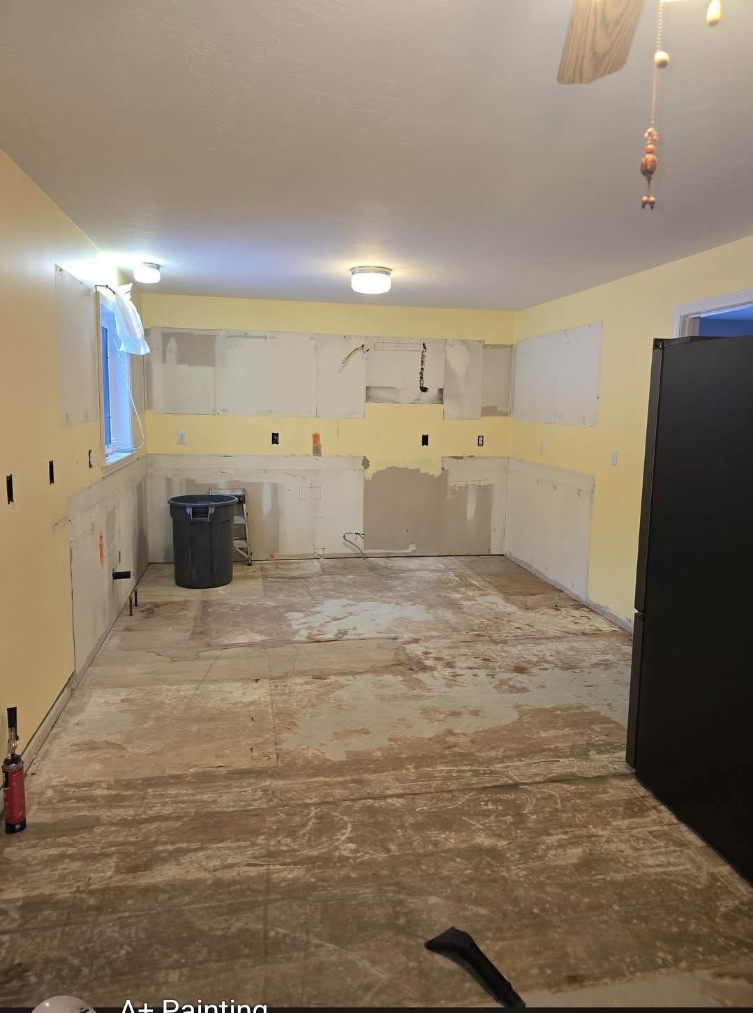 Kitchen stripped to studs and subfloor at the start of a full renovation